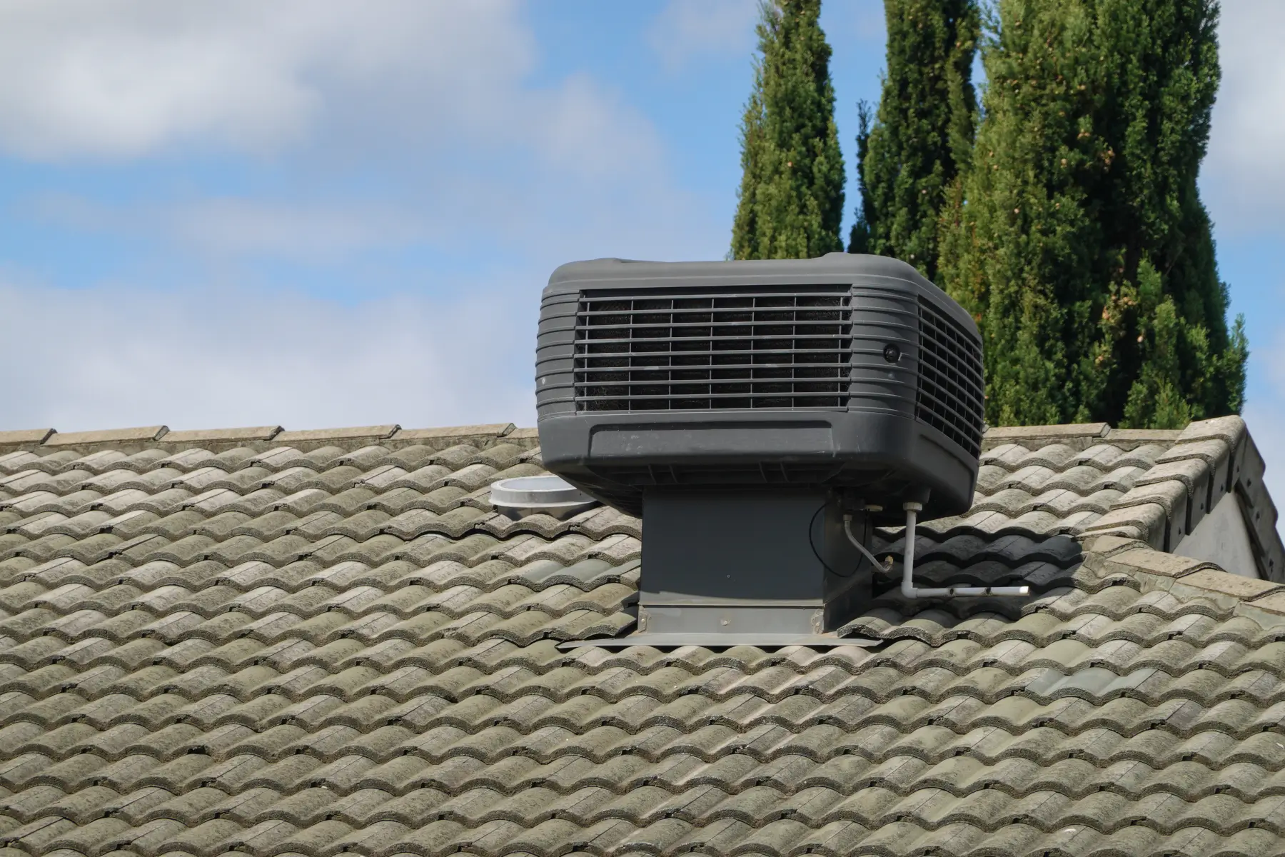 swamp-cooler-vs-central-ac-colorado-springs Swamp cooler mounted on a home roof compared to central air conditioning in Colorado Springs